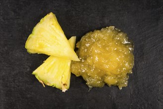 Portion of Pineapple Jam as detailed close up shot on a slate slab, selective focus