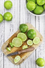 Sliced Limes on rustic wooden background (close-up shot)