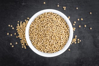 Portion of Mustard Seeds as detailed close up shot on a slate slab (selective focus)