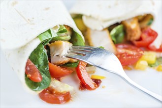 Chicken Wraps on a wooden table as detailed close-up shot (selective focus)