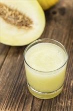 Fresh made Honeydew Melon smoothie (close-up shot, selective focus) on a wooden table