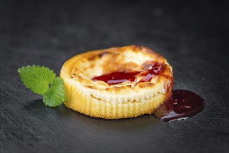 Cheesecake with Sauce on a vintage slate slab (close-up shot, selective focus)