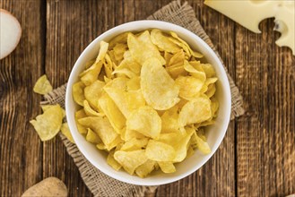 Cheese and Onion Potato Chips on a vintage background as detailed close-up shot (selective focus)