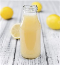 Homemade Lemon Juice on an wooden table (selective focus) as detailed close-up shot