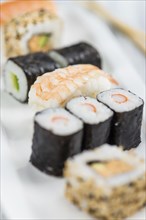 Portion of Sushi on a wooden table (selective focus, close-up shot)