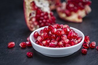 Portion of Pomegranate as detailed close up shot on a slate slab (selective focus)