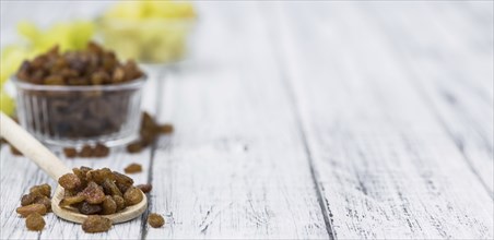 Vintage wooden table with Raisins (selective focus, close-up shot)