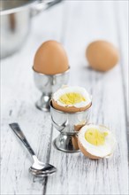 Some boiled Eggs (close-up shot, selective focus) on an old wooden table