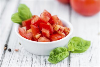 Cutted Tomatoes on an old wooden table as detailed close-up shot (selective focus)