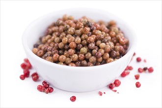 Preserved Pink Peppercorns isolated on white background, selective focus, close-up shot