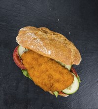 Fresh made Chicken Schnitzel on a bun (close-up shot, selective focus)