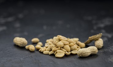 Roasted and salted Peanuts on vintage background (close-up shot, selective focus)