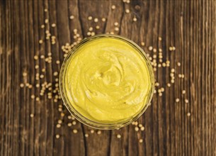 Mustard as high detailed close-up shot on a vintage wooden table (selective focus)