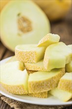 Honeydew Melon on an old wooden table as detailed close-up shot (selective focus)