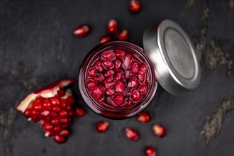 Healthy preserved Pomegranate seeds on a vintage slate slab (close-up shot, selective focus)