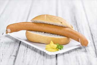 Sausages (Frankfurter) on rustic wooden background (close-up shot)