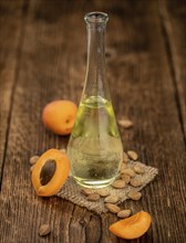 Portion of Apricot Oil with some fresh fruits as detailed close up shot (selective focus)