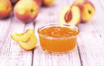 Homemade Peach Jam on an wooden table as detailed close-up shot, selective focus