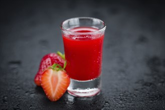 Strawberry liqueur on a vintage slate slab as detailed close-up shot, selective focus