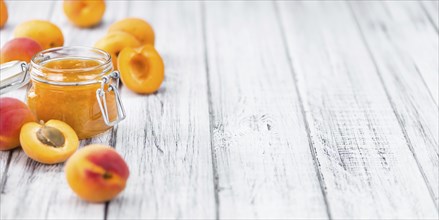 Apricot Jam as high detailed close-up shot on a vintage wooden table (selective focus)