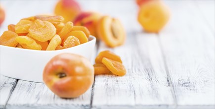 Dried Food (Apricots) on an old wooden table as detailed close-up shot (selective focus)