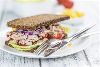 Old wooden table with Tuna sandwich (on wholemeal bread, selective focus)