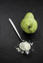 Portion of fresh made Pear powder on a slate slab (selective focus)
