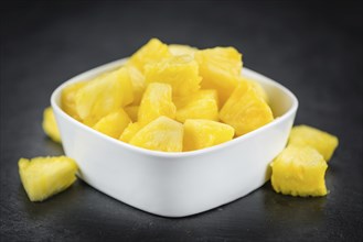 Portion of Sliced Pineapple as detailed close up shot on a slate slab, selective focus