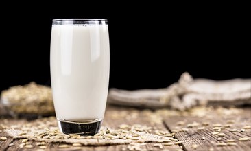 Wooden table with Oat Milk (detailed close-up shot, selective focus)