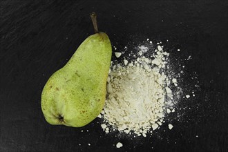Portion of fresh made Pear powder on a slate slab (selective focus)