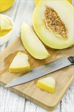 Fresh made Yellow Honeydew Melon on a vintage background (close-up shot)