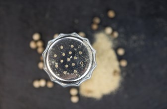 Portion of White Pepper as detailed close up shot on a slate slab, selective focus