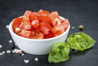 Some fresh Diced Tomatoes on a vintage slate slab (selective focus, close-up shot)