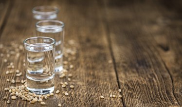 Vintage wooden table with Wheat Liqueur (selective focus, close-up shot)