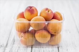 Fresh Apricots as high detailed close-up shot on a vintage wooden table (selective focus)