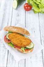 Fresh made Chicken Schnitzel on a bun (close-up shot, selective focus)