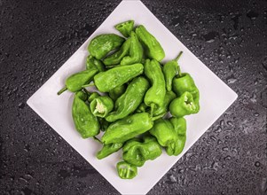 Portion of Raw Pimientos on a rustic slate slab, selective focus, close-up shot