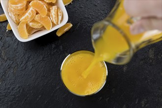 Portion of fresh made Tangerine Juice (close-up shot, selective focus)