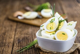 Halved Eggs on wooden background (close-up shot, selective focus)