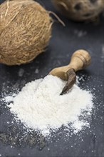 Healthy Coconut flour on a vintage slate slab (close-up shot, selective focus)