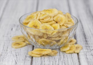 Fresh made Dried Banana Chips on an old and rustic wooden table, selective focus, close-up shot