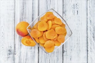 Dried Food (Apricots) on rustic wooden background (close-up shot)
