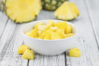 Sliced Pineapple on an old wooden table as detailed close-up shot, selective focus