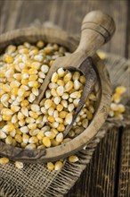 Portion of Corn (detailed close-up shot) on wooden background (selective focus)