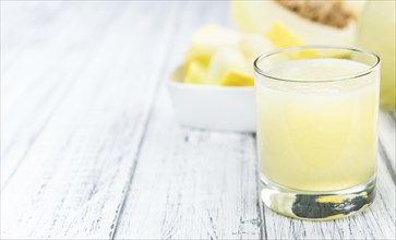 Honeydew Melon smoothie (close-up shot, selective focus) on a wooden table