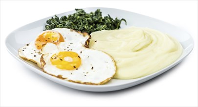 Fresh made Mash with fried eggs and spinach isolated on white background (close-up shot)