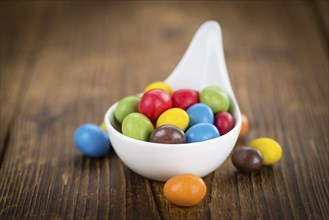 Fresh made Cocolate coated Peanuts on a vintage background (close-up shot)