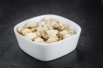 Marinated Garlic on a vintage slate slab (close-up shot, selective focus)