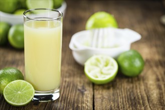 Fresh made Fresh Lime Juice on an old and rustic wooden table (selective focus, close-up shot)