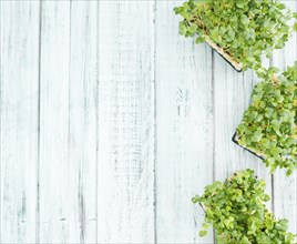 Fresh Cress as high detailed close-up shot on a vintage wooden table (selective focus)